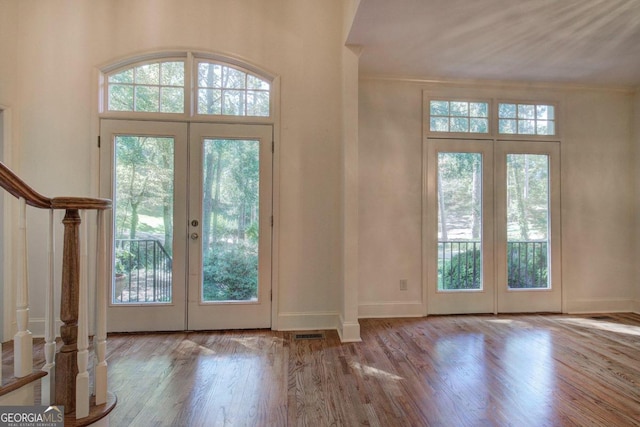 doorway featuring light hardwood / wood-style floors, ornamental molding, and french doors