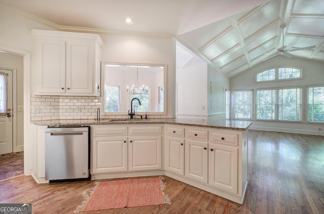 kitchen with sink, stainless steel dishwasher, vaulted ceiling, white cabinets, and ceiling fan with notable chandelier