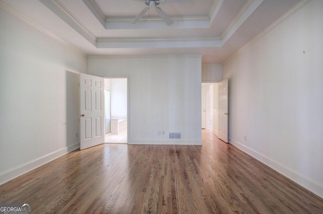 spare room with hardwood / wood-style flooring, ornamental molding, and a tray ceiling