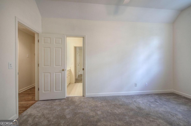 carpeted spare room featuring ceiling fan and lofted ceiling