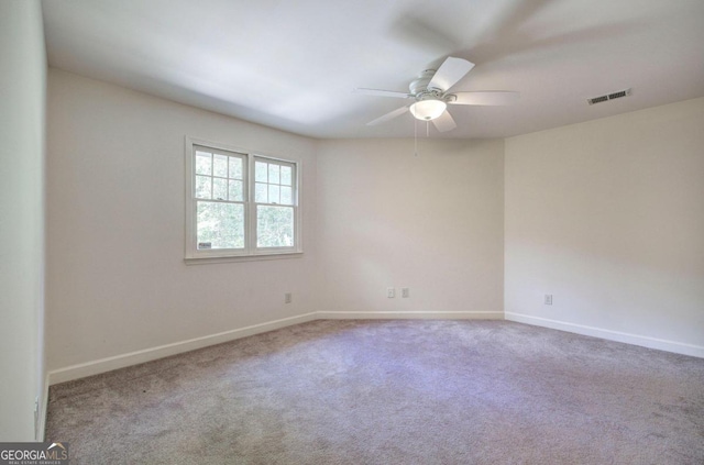 empty room featuring ceiling fan and carpet