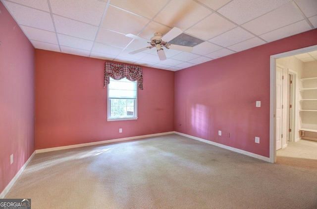 empty room with a paneled ceiling, ceiling fan, and carpet floors