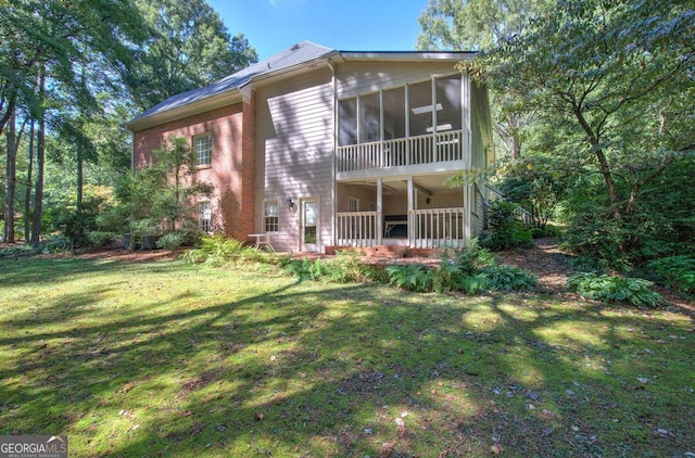 back of house with a yard and a sunroom