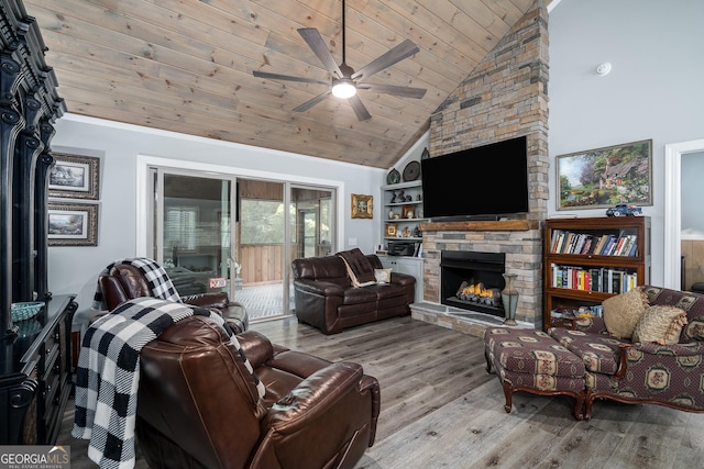 living room featuring high vaulted ceiling, a stone fireplace, light hardwood / wood-style flooring, ceiling fan, and wood ceiling