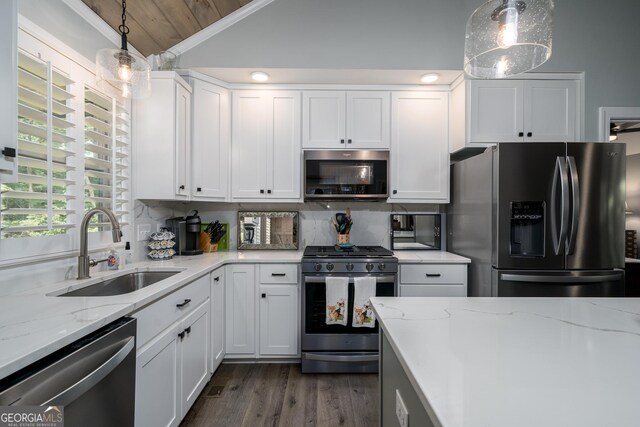 kitchen featuring white cabinets, appliances with stainless steel finishes, decorative light fixtures, and sink