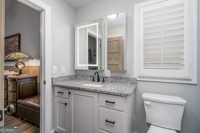 bathroom featuring hardwood / wood-style floors, vanity, and toilet