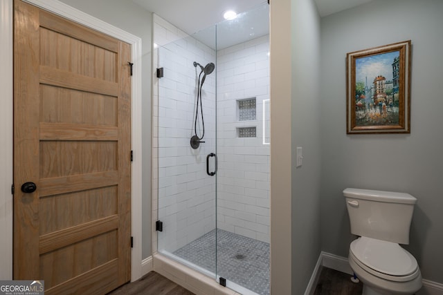 bathroom featuring hardwood / wood-style flooring, toilet, and walk in shower