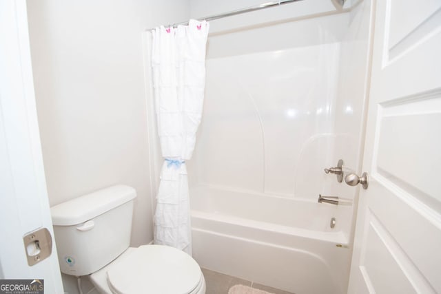 bathroom featuring tile patterned floors, shower / bath combination with curtain, and toilet