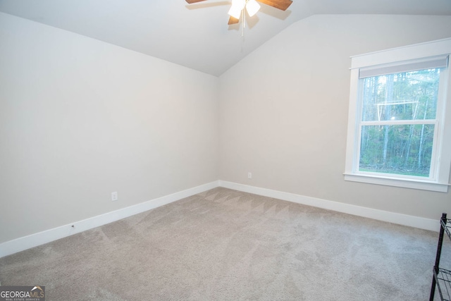 spare room featuring ceiling fan, light colored carpet, and lofted ceiling