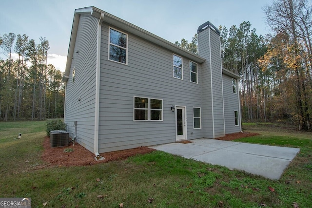 rear view of house featuring a lawn, a patio area, and central air condition unit