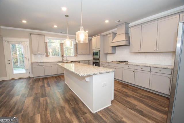 kitchen featuring dark hardwood / wood-style flooring, custom range hood, stainless steel appliances, pendant lighting, and a kitchen island