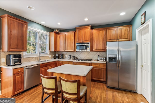 kitchen featuring a center island, light hardwood / wood-style floors, sink, and appliances with stainless steel finishes