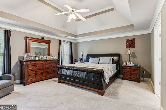 carpeted bedroom with a tray ceiling, ceiling fan, and ornamental molding