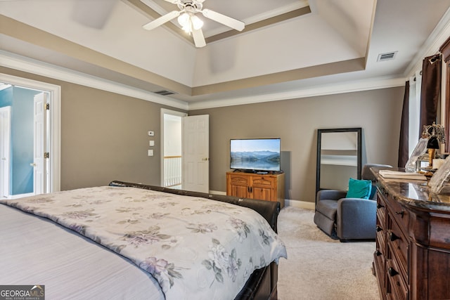 carpeted bedroom featuring a tray ceiling, ceiling fan, and crown molding