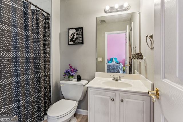 bathroom with vanity, toilet, and curtained shower