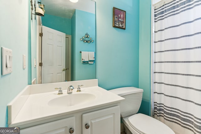 bathroom with walk in shower, vanity, and toilet