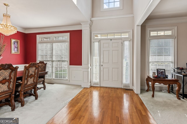 entryway with crown molding, a healthy amount of sunlight, and wood-type flooring