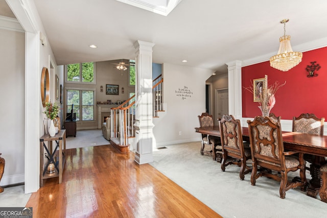 dining space featuring hardwood / wood-style floors, ceiling fan with notable chandelier, lofted ceiling, and ornamental molding