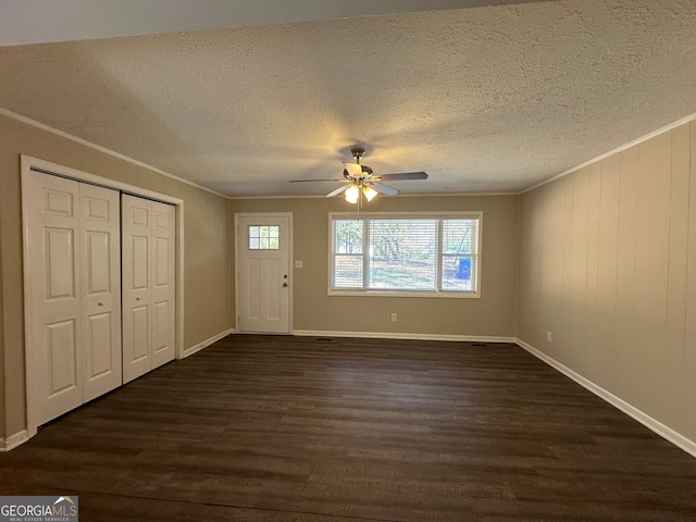 foyer entrance featuring ornamental molding, ceiling fan, and dark wood-type flooring