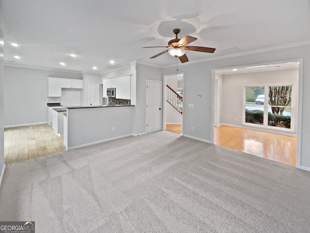 unfurnished living room with ceiling fan, light carpet, and ornamental molding