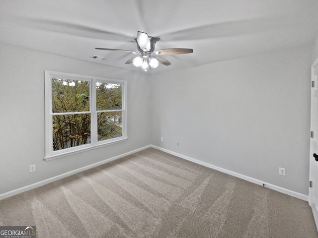 spare room featuring ceiling fan and carpet