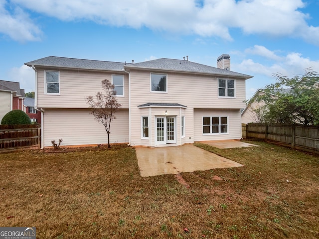 back of house with a lawn and a patio area