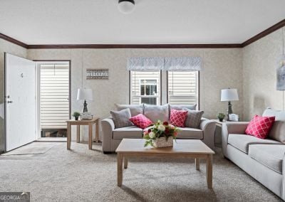 carpeted living room with a healthy amount of sunlight and ornamental molding