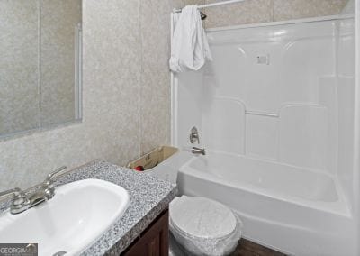 full bathroom with washtub / shower combination, vanity, and toilet