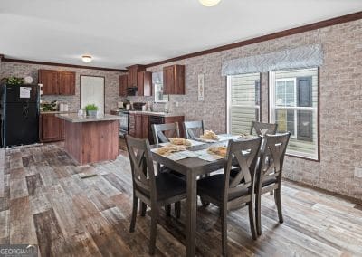 dining room with wood-type flooring, ornamental molding, and brick wall