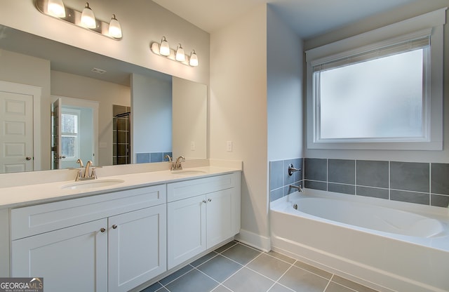 bathroom with vanity, a tub to relax in, and tile patterned floors