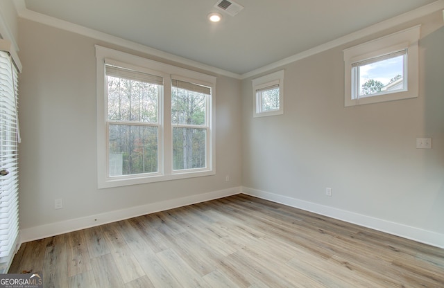 empty room featuring ornamental molding and light hardwood / wood-style flooring