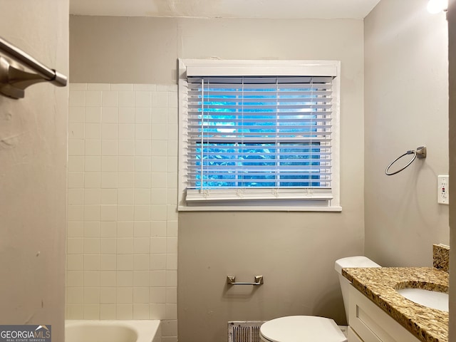 bathroom with vanity, toilet, and a tub