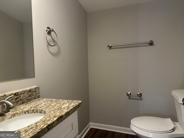 bathroom featuring hardwood / wood-style floors, vanity, and toilet