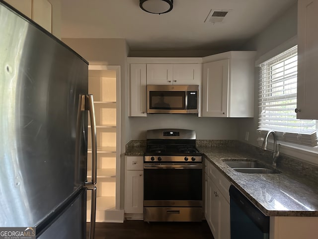 kitchen with dark hardwood / wood-style flooring, sink, white cabinets, and appliances with stainless steel finishes