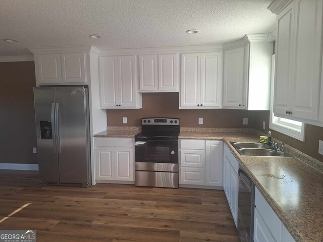 kitchen with dark hardwood / wood-style flooring, white cabinetry, sink, and stainless steel appliances