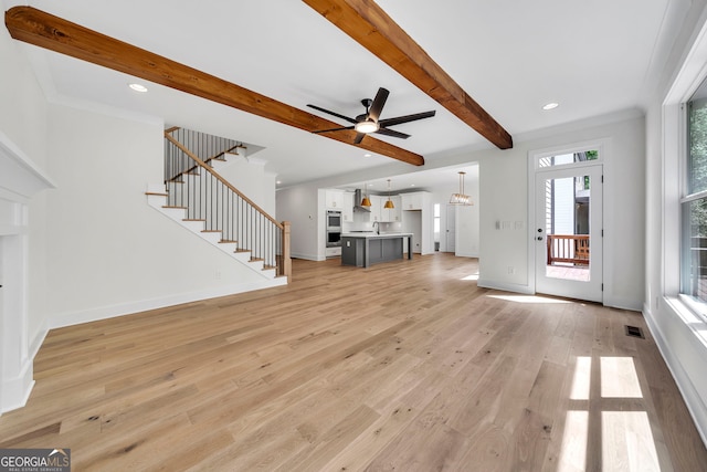 unfurnished living room featuring beam ceiling, ceiling fan, sink, crown molding, and light hardwood / wood-style floors