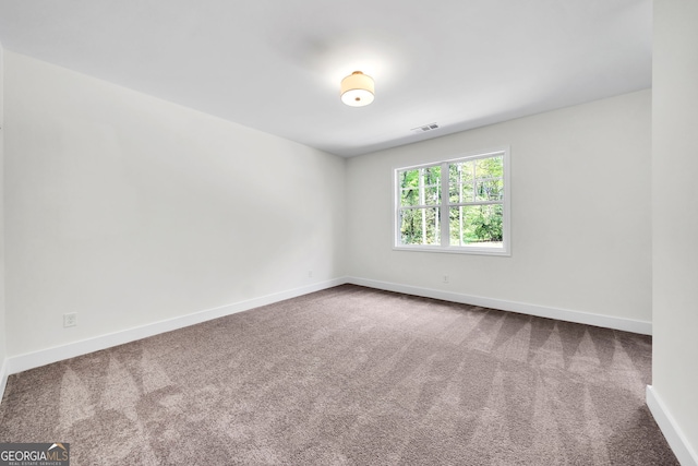 carpeted spare room with baseboards and visible vents