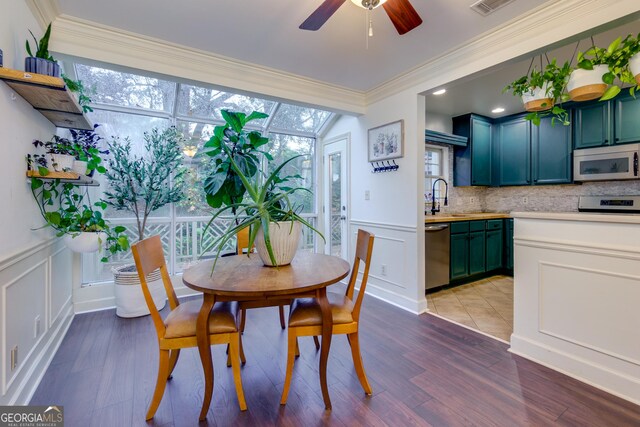 dining space featuring dark hardwood / wood-style flooring, ceiling fan, ornamental molding, and sink