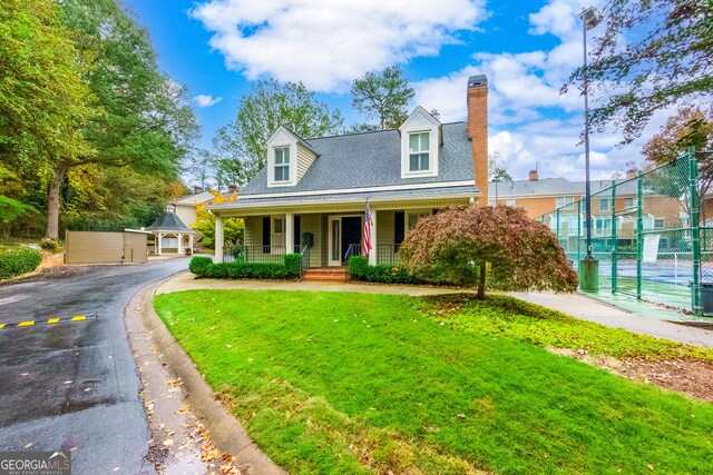 cape cod home with a front yard and a porch