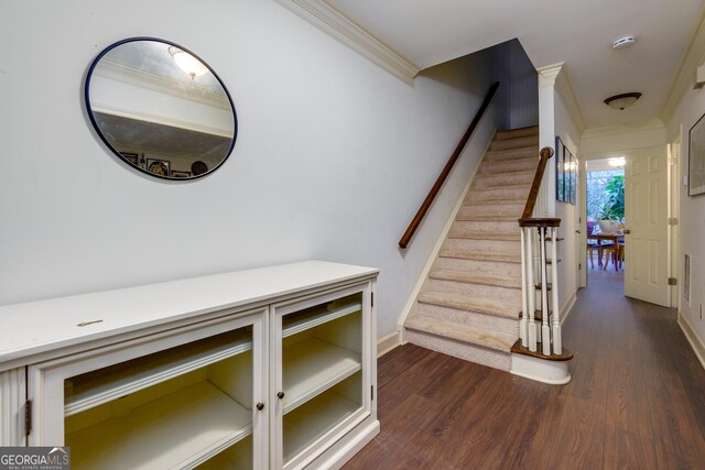 staircase with hardwood / wood-style floors and ornamental molding