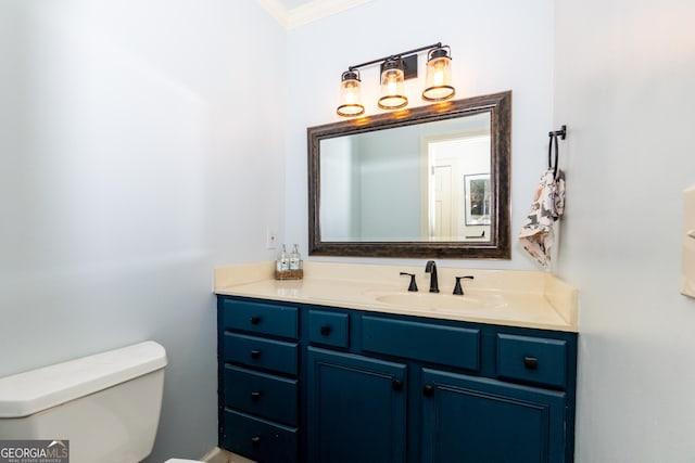 bathroom with vanity, toilet, and ornamental molding