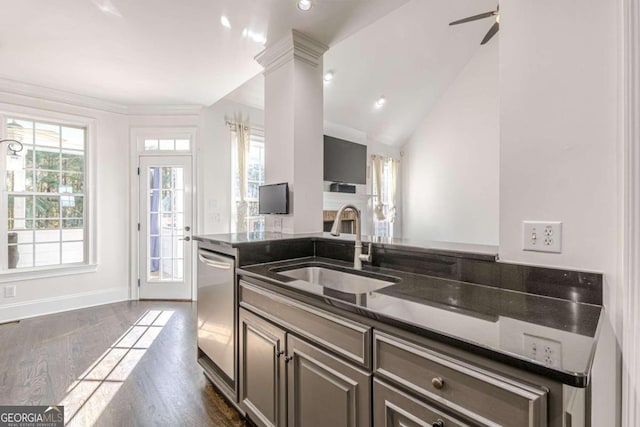 kitchen featuring dark hardwood / wood-style flooring, decorative columns, stainless steel dishwasher, sink, and lofted ceiling