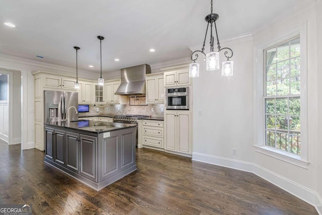 kitchen featuring pendant lighting, dark hardwood / wood-style flooring, wall chimney range hood, and appliances with stainless steel finishes