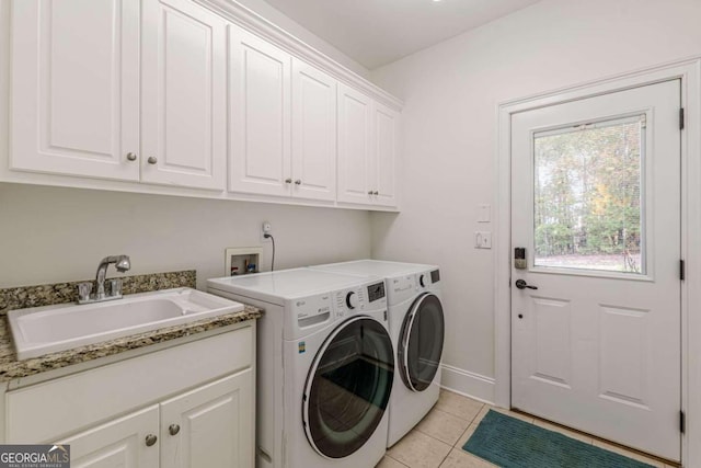 laundry room with cabinets, independent washer and dryer, light tile patterned floors, and sink