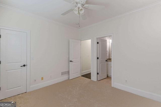 unfurnished bedroom featuring ceiling fan, crown molding, connected bathroom, and light carpet