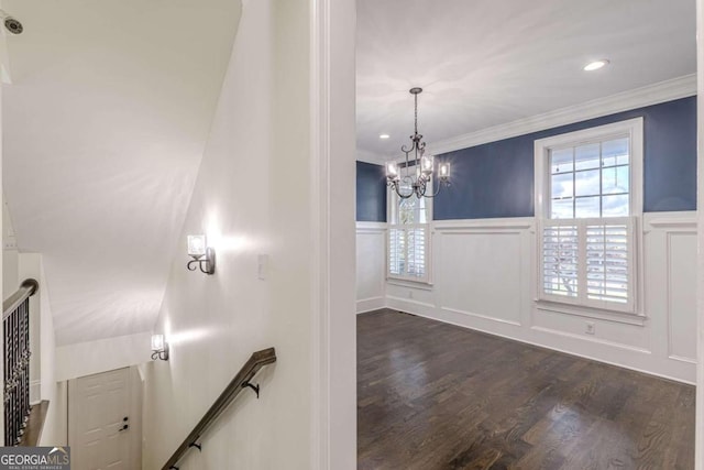 interior space with dark hardwood / wood-style flooring, crown molding, and a notable chandelier