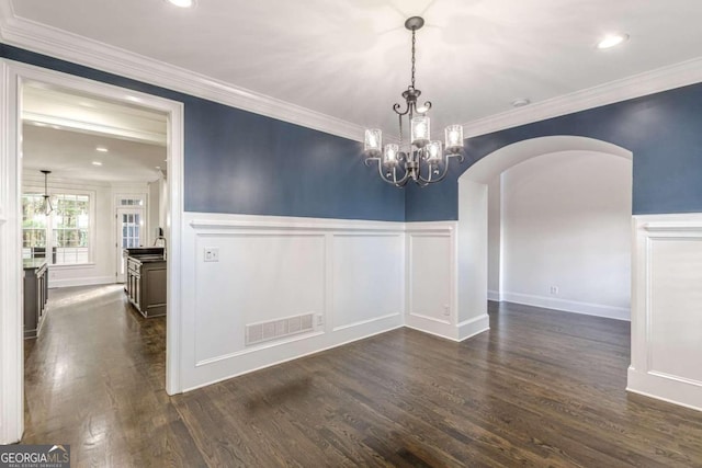 unfurnished dining area with dark wood-type flooring, a notable chandelier, and ornamental molding