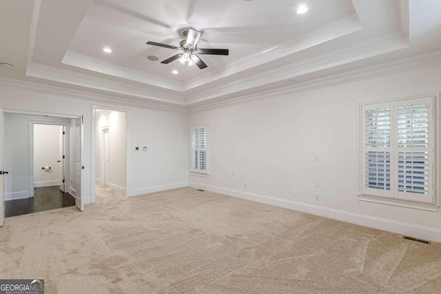 unfurnished bedroom featuring carpet, a tray ceiling, ceiling fan, and ornamental molding