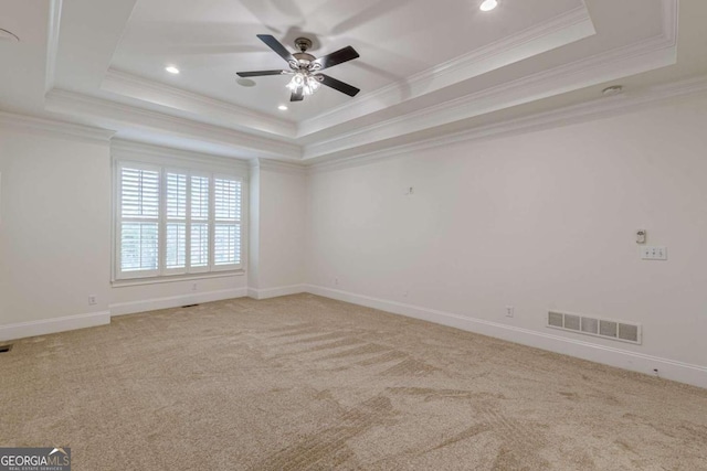 carpeted empty room featuring a raised ceiling, ceiling fan, and ornamental molding