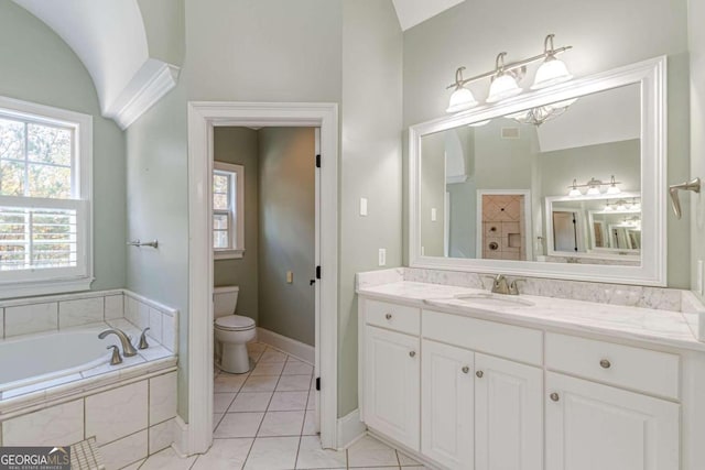 bathroom featuring tile patterned flooring, tiled tub, vaulted ceiling, toilet, and vanity